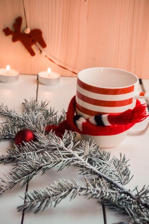 Fir branches with christmas decorated cup on white wooden background. Cozy magical xmas atmosphere. Preparing for winter holidays concept, copy spaceの写真素材