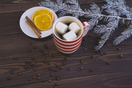 Cup of coffee and christmas snow fir branch on wooden tableの写真素材