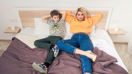 Mother with son on bed, mother and son having funの写真素材