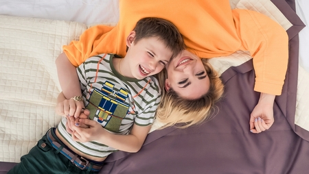 Mother with son on bed, mother and son having funの写真素材