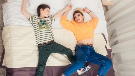 Mother with son on bed, mother and son having funの写真素材