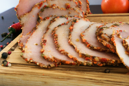 Fresh ham with spices on wooden board closeup