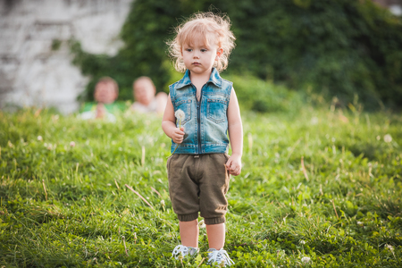 Cute little boy at summer day on green lawnの写真素材