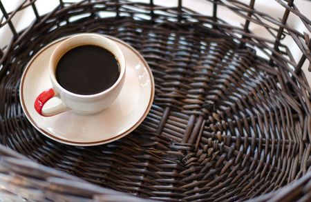 Cup of hot coffee on wicker basketsの写真素材