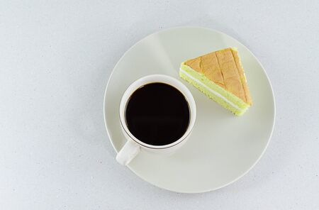 Coffee cup pandan sponge cake isolated on dish White backgroundの写真素材