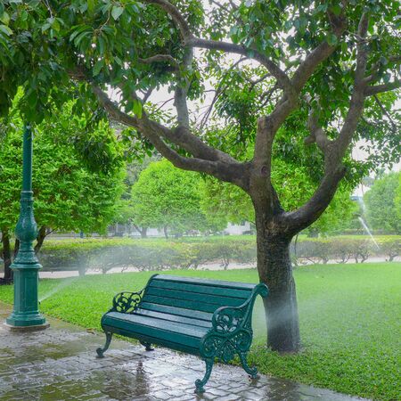 Wet chair with sprinkle water in the parkの写真素材