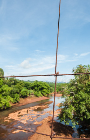 The suspension bridge over the river in the countrysideの写真素材