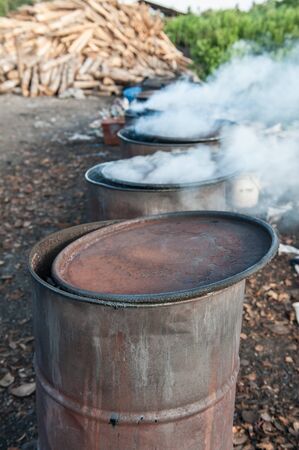 Coconut shell charcoal in steel drums.の写真素材