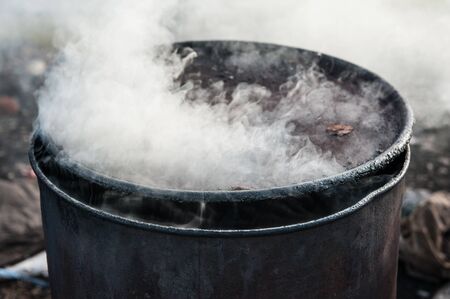 Coconut shell charcoal in steel drums.