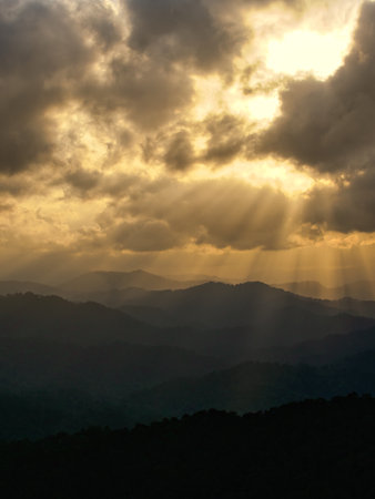 Sunset in the mountains with clouds and sunbeams, Thailand
