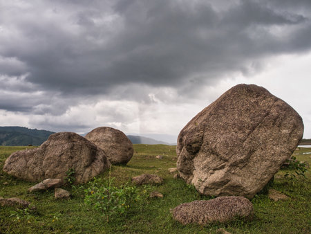 Rocks in the grasslands of the Khlong Din Daeng reservoir during the rainy seasonの写真素材