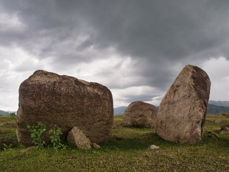 Rocks in the grasslands of the Khlong Din Daeng reservoir during the rainy seasonの写真素材