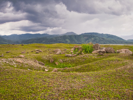 Rocks in the grasslands of the Khlong Din Daeng reservoir during the rainy seasonの写真素材