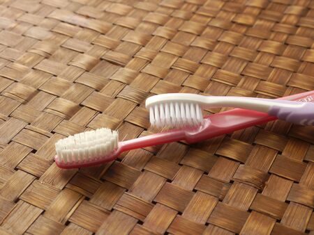 TWO TOOTHBRUSHES ON WICKER BACKGROUNDの写真素材