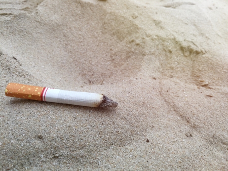 Cigarette on beach with morning light.