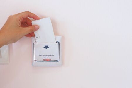 Soft Focus on Hand insert key card for on power electric equipment in the hotel room, Hotel Lock...