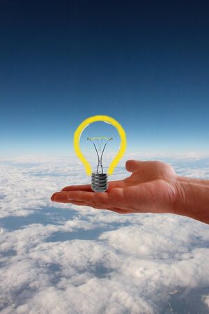 Light bulb in hand on aerial sky view backgroundの写真素材