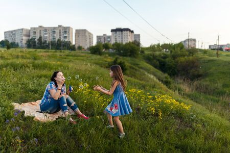 daughter reveals to her mother at something interesting at the sunsetの写真素材
