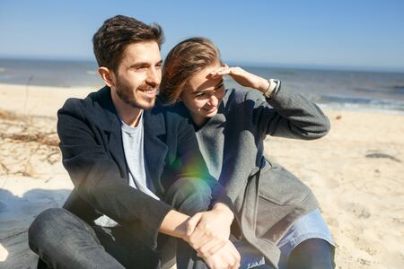Happy young couple spending time on the sea shore in springの写真素材
