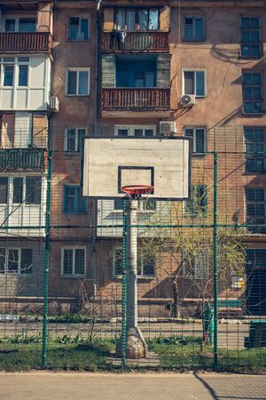 Basketball hoop with backboard in residential district for street basketball game, outdoors sports and recreation, urban environment, retro toned imageの写真素材