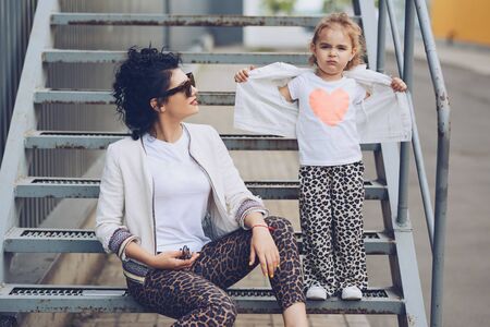 Cheerful mother and daughter having fun in city