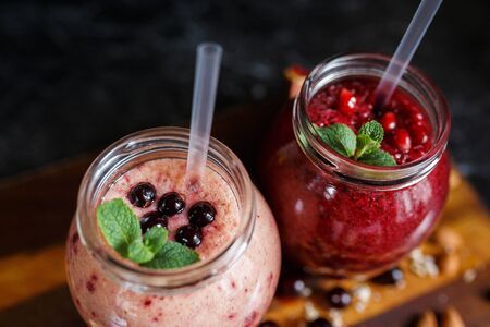 freshly prepared smoothies from banana with pomegranate and banana with blackberry in bottle. Diet, healthy lifestyleの写真素材