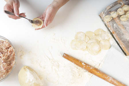 homemade dumplings in the kitchen without decorations. making dumplings with minced pork, beef and...
