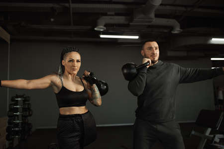 A disabled girl is engaged in the gym A woman with one leg trains with a trainer, she works hard and...
