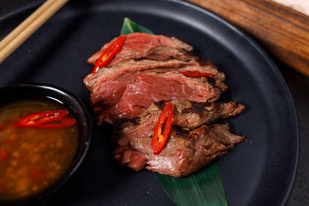 Beef tataki served on hot salt with sauceの写真素材