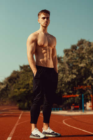 young guy with athletic body getting ready to runの写真素材