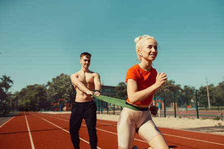 Young couple doing sports with sports rubber bandsの写真素材