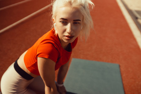 close-up portrait of a beautiful blonde who is sitting on a jogging trackの写真素材