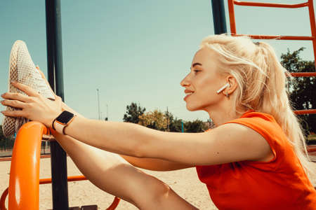 beautiful blonde doing stretching on the playground