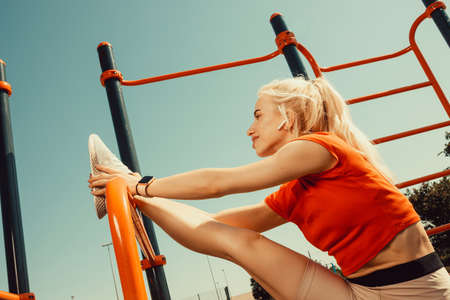 beautiful blonde doing stretching on the playgroundの写真素材