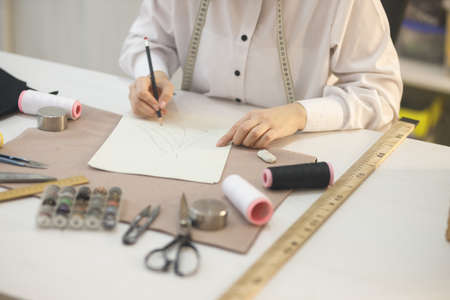 the seamstress makes a sketch of the future dress for sewing
