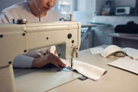 young girl seamstress while working on tailoring in her workshop