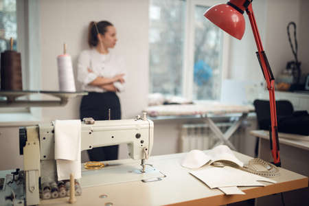 young girl seamstress posing in front of her tailoring workshopの写真素材