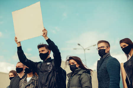 A group of people with mask who came out with posters to protest The protest of the population against coronavirus and against the introduction of quarantine Meeting about coronavirus and people rights. Copyspaceの写真素材