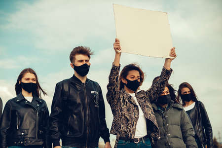 A group of people with mask who came out with posters to protest The protest of the population against coronavirus and against the introduction of quarantine Meeting about coronavirus and people rights. Copyspaceの写真素材