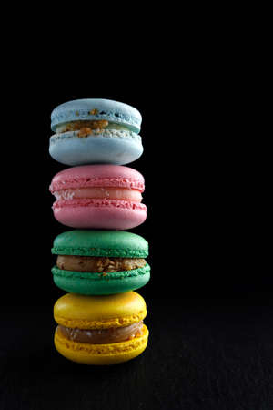 four multi-colored homemade natural products macaroon on a black background.の写真素材