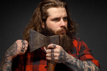 handsome man with long hair cuts his hair with an ax like a barbershop.の写真素材