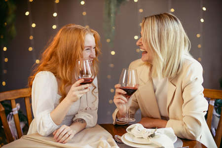 lesbian couple having dinner in a restaurant Girls drink wine and talk