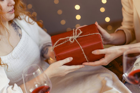 lesbian couple having dinner in a restaurant Girl giving a gift to her sweetheartの写真素材