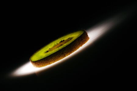 Kiwi fruit slice on black backgroundの写真素材