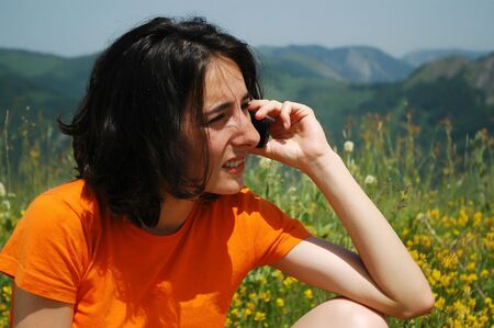 Happy woman enjoying the outdoors using her cell phone の写真素材