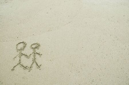 Simple couple drawing in the sand on the beachの写真素材
