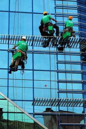 CLUJ NAPOCA  MAY 03: Unidentified workers washing the windows facade of a new build bank before the official opening on May 03, 2011 in Cluj Napoca, Romaniaのeditorial素材