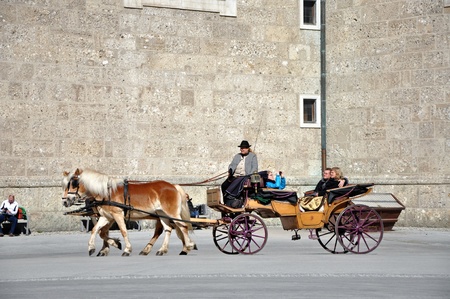 SALZBURG - MARCH 13: Horse driven carriage with tourists at Spring Days, visiting the famous city of Salzburg, part of Unesco heritage where the composer, W.A. Mozart was born. On March 13, 2012 in Salzburg, Austriaのeditorial素材
