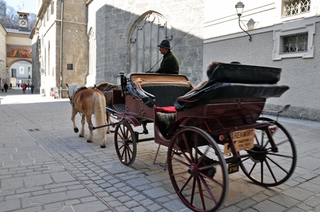 SALZBURG - MARCH 13: Horse driven carriage with tourists near the Franciscan church, visiting the...