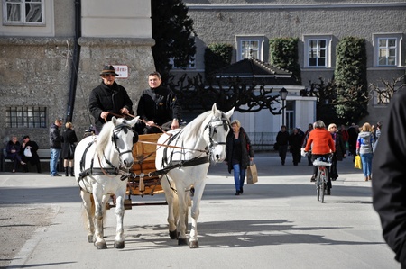 SALZBURG - MARCH 13: Horse driven carriage with tourists in Residenzplatz square, visiting the famous city of Salzburg, part of Unesco heritage where composer W.A. Mozart was born. On March 13, 2012 in Salzburg, Austriaのeditorial素材